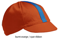 flat shot of the 4-panel cotton cap in burnt orange with a cyan ribbon